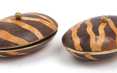 Maitland Smith, a pair of coconut shell inlaid boxes, late 20th Century, each of oval form, with tessellated inlaid decoration, brass ball finial and brass trim, each 14cm high, 31cm wide (2)