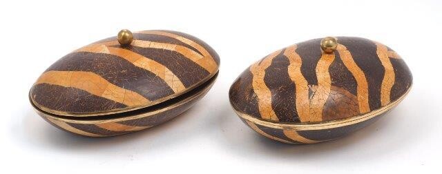 Maitland Smith, a pair of coconut shell inlaid boxes, late 20th Century, each of oval form, with tessellated inlaid decoration, brass ball finial and brass trim, each 14cm high, 31cm wide (2)