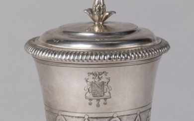 POT-À-FARD, or TIMBALE TULIPE COUVERTY of the Louis XIV period in silver, decorated at the half of the body with motifs of mantling alternating with lanceolate leaves. Pedestal with gadrooned frieze. The neck is underlined with fillets. The lid has a...