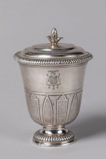 POT-À-FARD, or TIMBALE TULIPE COUVERTY of the Louis XIV period in silver, decorated at the half of the body with motifs of mantling alternating with lanceolate leaves. Pedestal with gadrooned frieze. The neck is underlined with fillets. The lid has a...