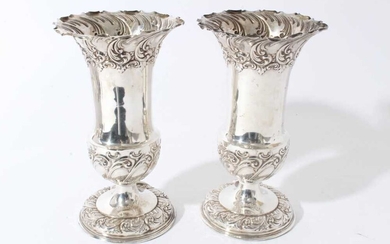 Pair of Edwardian silver spill vases, with embossed decoration scroll decoration and flared rims, raised on circular pedestal (Sheffield 1902)