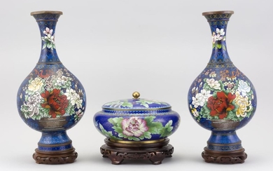 THREE PIECES OF CHINESE CLOISONNÉ ENAMEL A pair of vases with polychrome floral decoration on a blue ground, and a lidded bowl with...