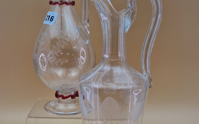 TWO LATE VICTORIAN BALUSTER GLASS EWERS, BOTHER WITH HOLLOW HANDLES, ONE ENGRAVED WITH TRAILING