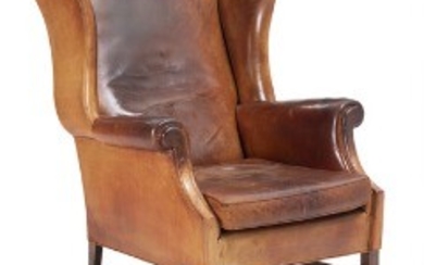 1918/117 - An English patinated leather wingback chair with mahogany base. Circa 1930-40's.