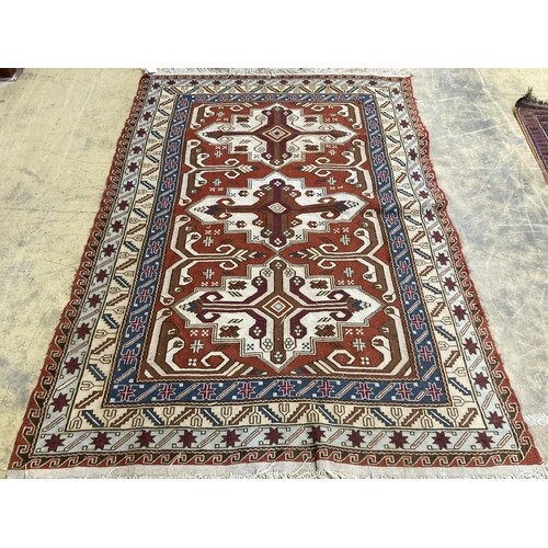 A Caucasian design red ground rug, 240 x 165 cms. ...
