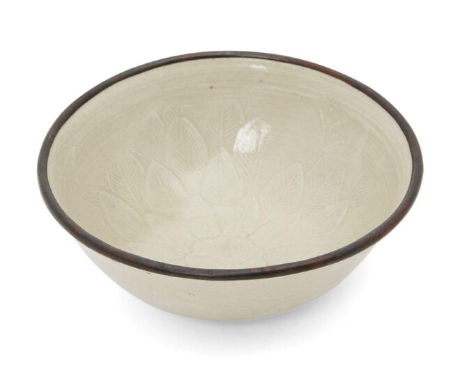 A Chinese Dingyao 'floral' bowl, Northern Song - Jin Dynasty, the interior with a moulded lotus bloom sprouting from several layers of leaves, with allover ivory-white glaze and metal rim, 9.2cm diameter Provenance: Sotheby's Hong Kong, 27 November...