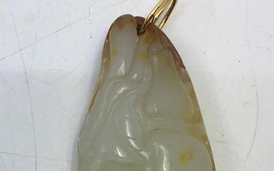 A Chinese carved celadon jade pendant with russet inclusions
