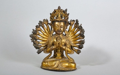 A GILT-BRONZE FIGURE OF CUNDI BODHISATTVA. Ming Dynasty. The eighteen-armed bodhisattva is cast seated in dhyanasana with the primary hands held in the Cundi root mudra, draped in garlands to the chest and wears a flowing dhoti, tied at the waist...