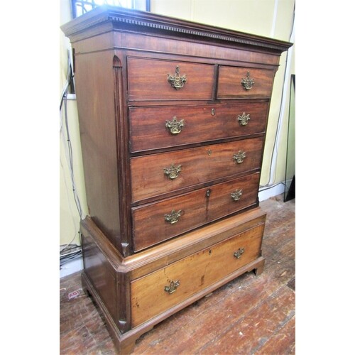 A Georgian mahogany chest on stand, the upper section fitted...