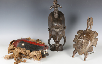 A Senufo carved wooden mask, Ivory Coast, length 43cm, together with two other African masks.