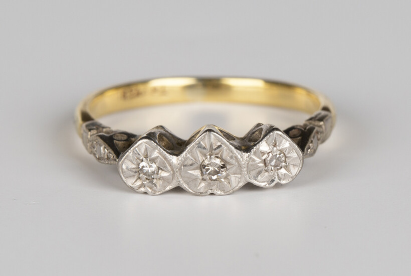 A gold and platinum ring, mounted with three circular cut diamonds in heart shaped settings, detaile