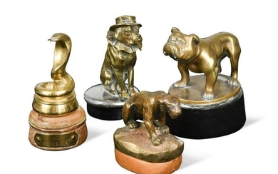A group of four brass car mascots