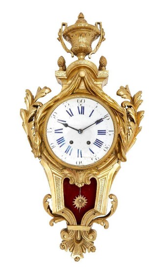 A large French gilt-bronze cartel clock, late 19th century, the case surmounted by a twin-handled urn flanked by acorn finials, with scrolling foliate decoration and pierced foliate frieze to sides, the convex enamel dial with blue Roman and black...