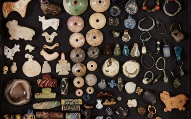 A large group of mainly Near Eastern and Eastern Mediterranean beads and amulets Late 5th Millennium B.C. - 1st Millennium A.D. and Later Including fourteen shell, calcite and white stone amulets: a standing horned bull with concentric circle...