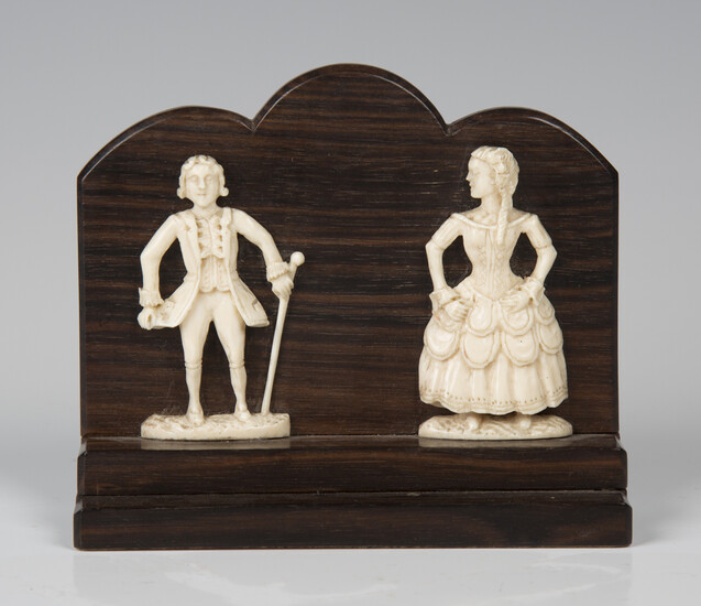 A pair of 19th century carved ivory flatback figures of a lady and gentleman, applied to a stepped r