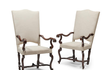 A pair of Continental baroque style walnut open armchairs