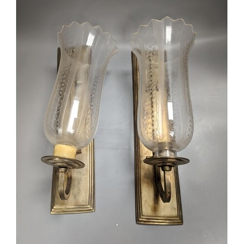 A pair of brass wall lights, with engraved glass storm shade...