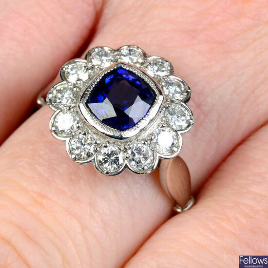 A platinum sapphire and brilliant-cut diamond cluster ring.