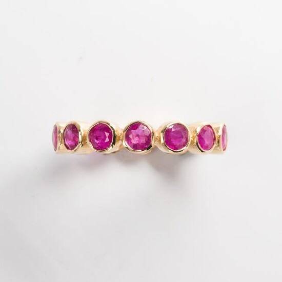 A ruby and eighteen karat gold eternity band ring