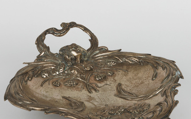 A silver Art Nouveau-period vide-poche. Presumably French. An embossed decor of a woman's head, roca