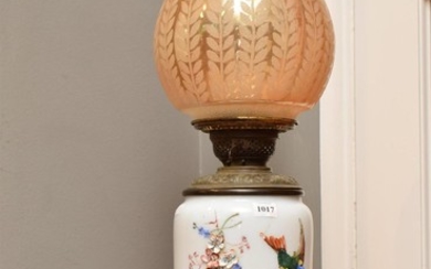 AN ANTIQUE OIL LAMP WITH EBOSSED HAND PAINTED DESIGNS DEPICTING BIRDS AND FLOWERS