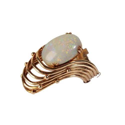 AN OPAL AND GOLD MODERNIST RING the oval-cut opal with green...