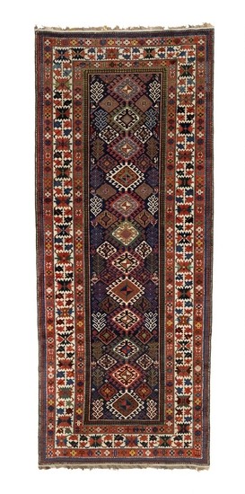 An antique Shirvan rug, Caucasus. Design of hooked linked diamonds on a blue field surrounded by a classical crab border. 19th century. 315×131 cm.