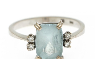 An aquamarine and diamond ring set with a fancy-cut aquamarine flanked by four brilliant-cut diamonds, mounted in 18k white gold. Size 56.