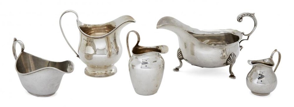 An assortment of five silver cream jugs,...