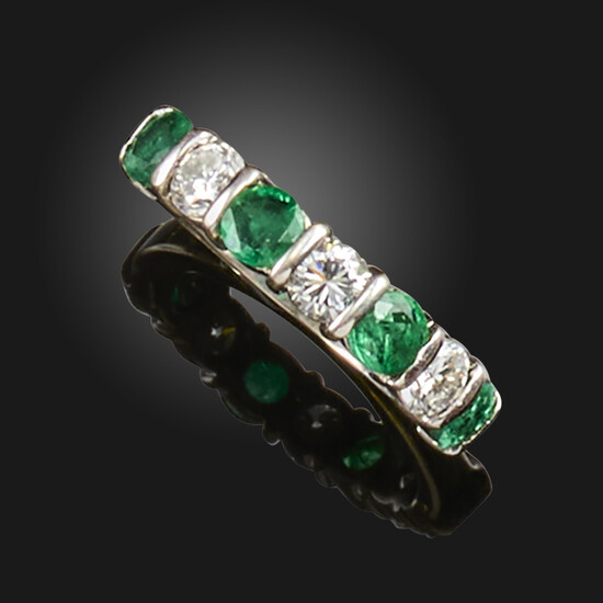 An emerald and diamond half hoop ring