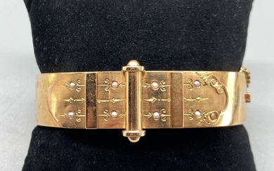 Bracelet Jonc plat ouvrant ancien en or jaune 18K (750/oo) agrémenté d'un motif orné de...