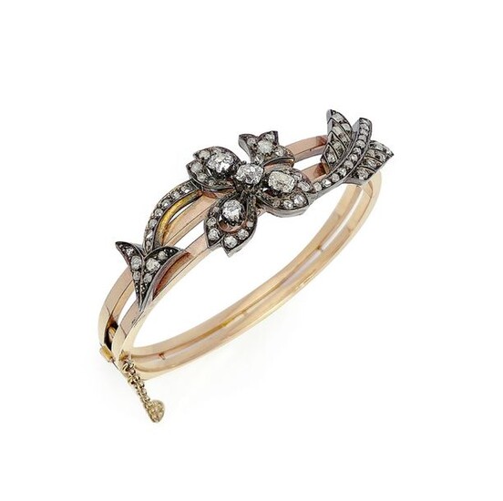 Bracelet jonc ouvrant en or jaune 18K (750/°°) et argent, orné d une flèche stylisée sertie de diamants taillés en rose. Poids brut : 22.9g