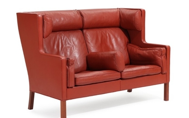 Børge Mogensen: “Kupé”. A two-seater sofa with mahogany legs, upholstered with reddish brown leather. Manufactured by Fredericia Furniture. L. 154 cm.