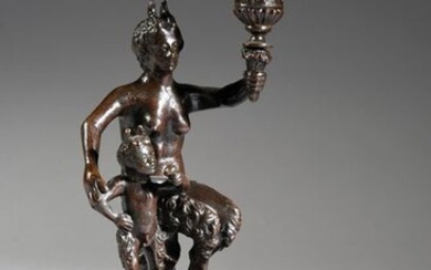 Candlestick in patinated bronze, resting on a triangular base with lion's paws, the shaft formed by a faun and a satyr sitting on a tree trunk and supporting a bowl with friezes of gadroons and acanthus leaves.