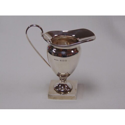 George V silver cream jug of baluster form, with loop handle...