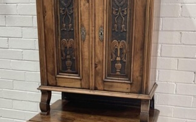 Late 19th Century German or Austrian Walnut Cabinet, with carved pelmet, the four doors with carved 'spurting' vase motifs, flanked...