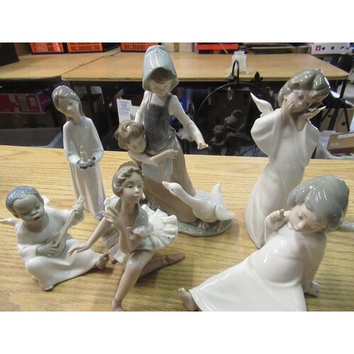 Lladro figurines of two angels, young boy angel playing musi...