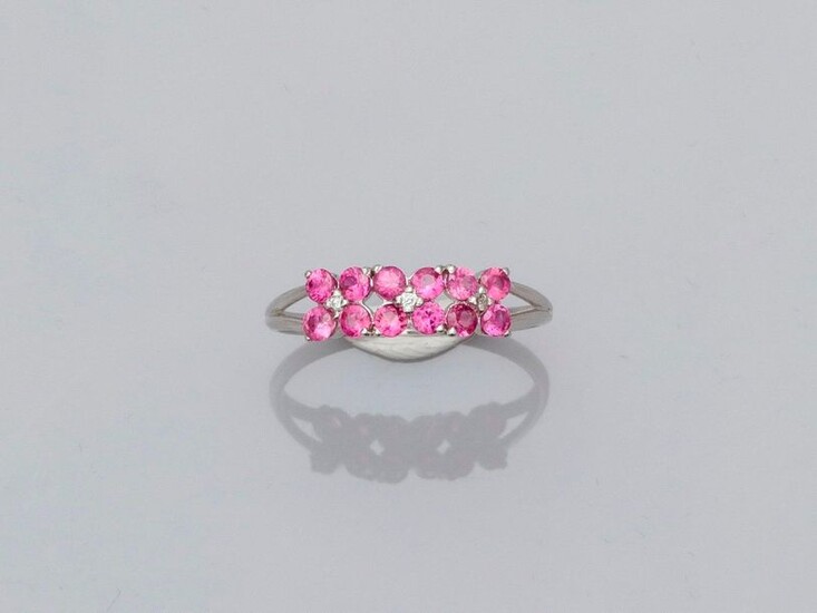 Ring in white gold, 750 MM, motif covered with round rubies interspersed with three diamonds, size: 53, weight: 1.8gr. rough.