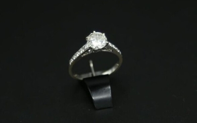 * Solitaire en or blanc 750 millièmes sertie d'un diamant rond taille brillant d'environ un carat épaulé des cinq petits diamants de chaque côté. Poids brut : 2.5 g / tdd 51 (égrisures)