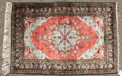 A FINE PERSIAN SILK RUG with central motif on a red