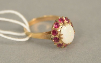 14K gold ring set with oval opal surrounded by red