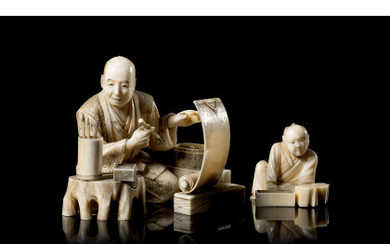An ivory okimono of a calligrapher with a student and various tools, signed Japan, Meiji period (1868-1912) (h. 5.5 cm.)