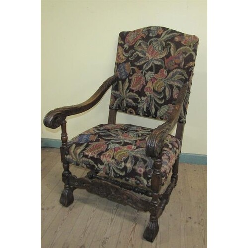 A 19c walnut framed and upholstered open arm chair with bold...