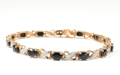 A 9ct gold, sapphire and diamond line bracelet. The bracelet...