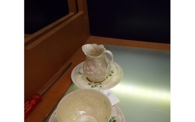 A Belleek milk jug, cup and saucers