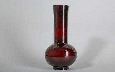 A CHINESE PEKING GLASS AMBER-RED VASE. The plain bulbous body with a cylindrical, gently flared neck raised on a splayed foot and embellished with a four character Qianlong mark to the base, 23cm H. 料長頸瓶，陰刻「乾隆年製」楷書款