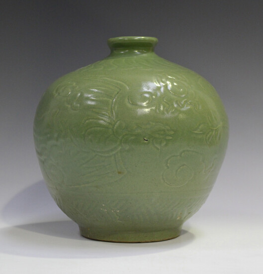 A Chinese celadon glazed vase, Ming style but probably Qing dynasty, of stout ovoid form, carved in