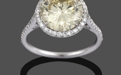A Diamond Cluster Ring, a fancy intense yellow round brilliant...
