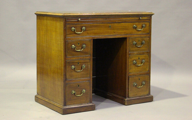 A George III mahogany kneehole desk, fitted with a brushing slide above an arrangement of oak-lined