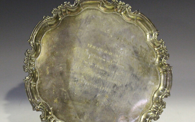 A George V silver circular salver with inscription within a raised scroll rim, on scroll feet, Sheff